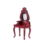 Miniature dollhouse dressing table in burgundy red featuring an ornate oval mirror, two small side drawers with gold knobs, and elegant curved cabriole legs in Victorian style.