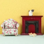 Miniature dollhouse fireplace featuring a classic burgundy painted wooden mantel with decorative carved detail, black insert with vertical grooves, and brown wooden top shelf.