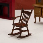 Miniature dark wood rocking chair, perfect for dollhouses and crafting projects.