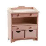 1:12 scale pink painted changing table featuring raised back panel, two drawers, open shelf space, and double cabinet doors, perfect for dollhouse nursery furniture.