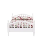 Miniature white bed featuring floral bedding, perfect for dollhouse decoration.