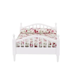 Miniature white bed featuring floral bedding, perfect for dollhouse decoration.