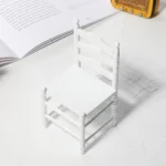 Miniature white slatted chair designed for dollhouses, perfect for adding charm to miniature scenes.