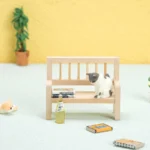 Miniature wooden garden bench with slatted back, perfect for dollhouse outdoor scenes and decor.