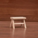 Miniature wooden stool with a simple design, perfect for dollhouse furnishings.