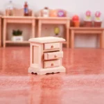 1:12 scale wooden painted nightstand featuring three small drawers with round knobs, decorative scalloped base, and clean modern design for dollhouse bedroom furniture.